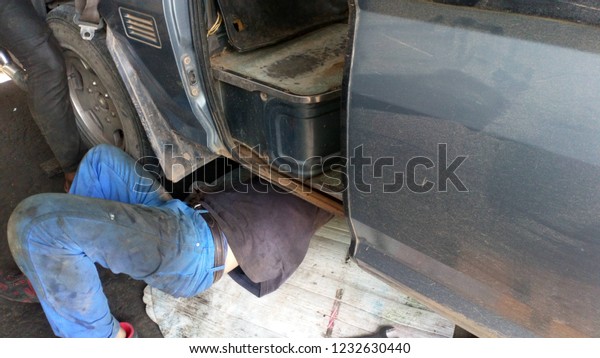 The\
mechanic is  under the car to repair the\
car.