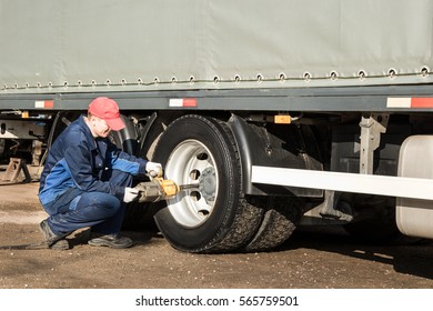 Mechanic Unscrews Wheel Truck Pneumatic Wrench