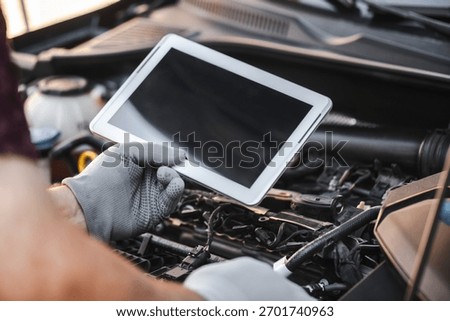 Mechanic uses a digital table to record error engine checks