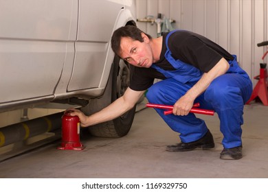 Mechanic Uses Jackscrew In The Auto Service