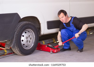 Mechanic Uses Jackscrew In The Auto Service