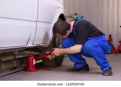 Mechanic Uses Jackscrew In The Auto Service