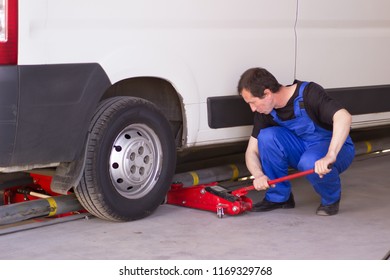 Mechanic Uses Jackscrew In The Auto Service