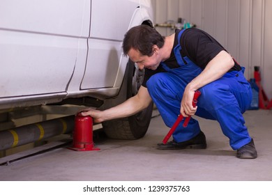 Mechanic Uses Jackscrew In The Auto Service