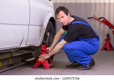 Mechanic Uses Jackscrew In The Auto Service