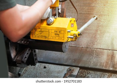 mechanic uses a magnet to lift the workpiece controlled by hand.
