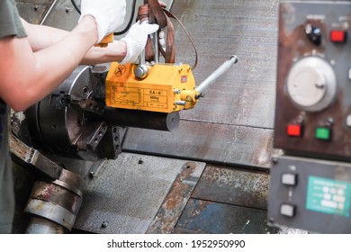 mechanic uses a magnet to lift the workpiece controlled by hand.