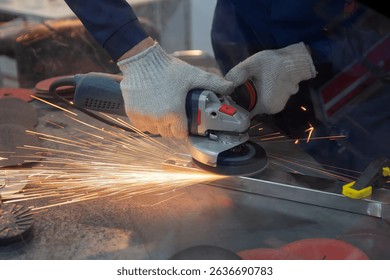 Mechanic using angle grinder and working with metal in workshop. Industry