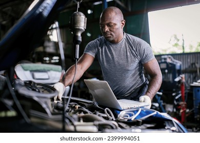 Mechanic using compute for Diagnostic  machine tools ready to be used with car. Car mechanic using a computer laptop to diagnosing and check up on car engines parts for fixing and repair - Powered by Shutterstock