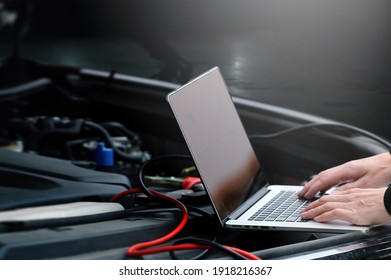 Mechanic Using Computer For Diagnostics Engine. Repairing Car. Blur Garage Auto Repair Service In Background.