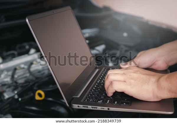 Mechanic using computer laptop for\
diagnostics engine. Repairing car Check various operating systems\
to check for abnormalities, service concept and\
technology