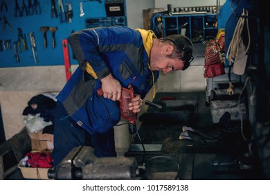 Mechanic Using Drill In Workshop While Repairing.