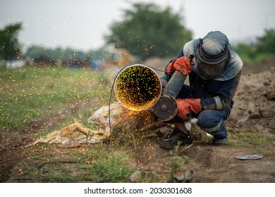 Mechanic Using Electric Grinder Tool With Protective Work Wear During Installation Of Natural Gas Pipeline In India, 