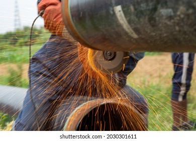 Mechanic Using Electric Grinder Tool With Protective Work Wear During Installation Of Natural Gas Pipeline In India, 