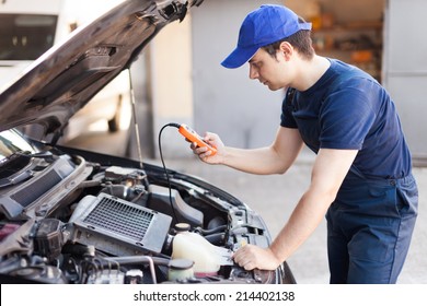 Mechanic Using An Electronic Tester On A Car Engine