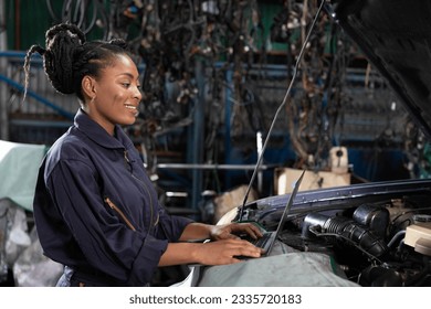 mechanic using laptop computer for checking and fixing a car in automobile repair shop