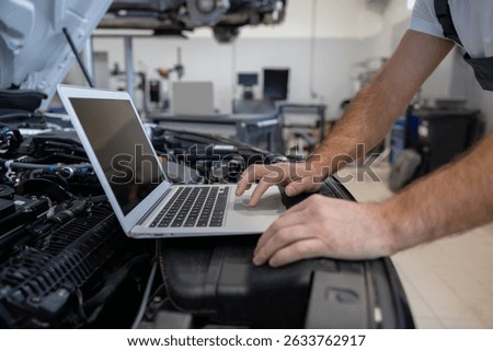Mechanic using laptop for diagnostics