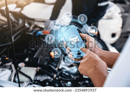 Mechanic using smart phone checking up on car engines parts for fixing and repair, Smart service diagnostics software concept.