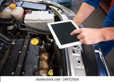 Mechanic Using Tablet To Fix Car At The Repair Garage