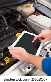 Mechanic Using Tablet To Fix Car At The Repair Garage