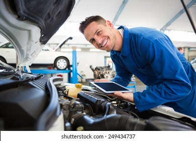 Mechanic Using Tablet On Car At The Repair Garage