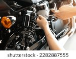 Mechanic using Tools set up suspension sag Compression and Rebound on a motorcycle in garage,maintenance motorcycle concept .selective focus