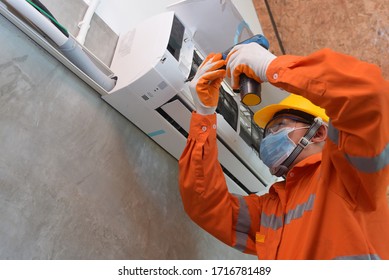 Mechanic Wearing Mask To Prevent Disease, Covid 19 Currently Using Electric Drill To Install Air Conditioner