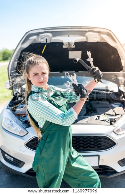 Mechanic woman\
posing with wrenches and\
spanners