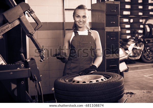 Mechanic\
woman working on car wheel in service\
point
