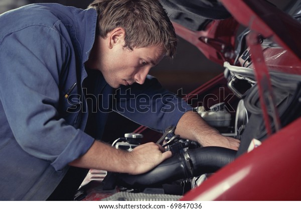 Mechanic at work\
fixing car in auto\
service