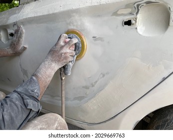 Mechanic Worker Repairman Fixing By Sanding Polishing Car Body And Preparing For Painting At Station Service. Auto Body Dent Removal Techniques