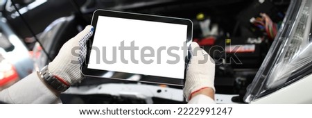 Mechanic worker using tablet for diagnostics of technical condition of vehicle