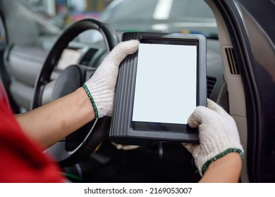 Mechanic working at car service center Use the scanner to diagnose car problems using OBD and OBD2 electronics on your tablet to fix problems in car repairs.