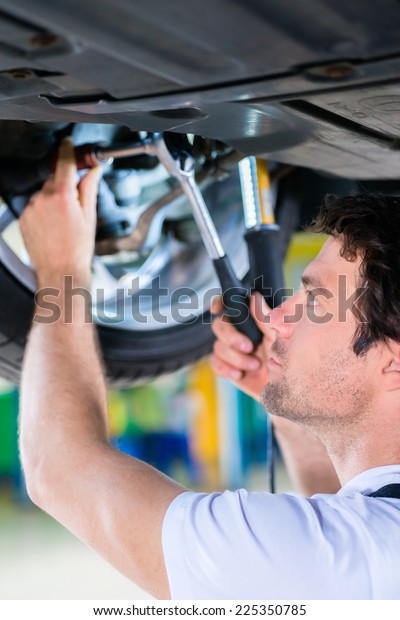 Mechanic working in car
workshop on wheel