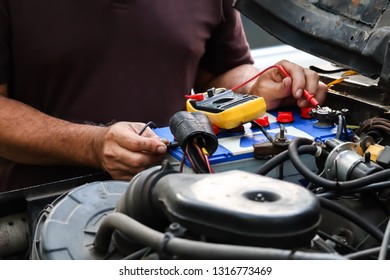 Mechanic Working With Digital Multimeter. Car Spare Parts And Off Road Car.