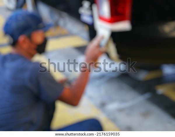 Blurred​ background​ for​ \
  mechanic\
is working to fix the car\'s paint after an\
accident.