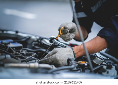 A Mechanic Is Working On A Broken Engine In A Mechanic Service Or Garage. Maintenance Of Transportation. Hands Of A Car Mechanic Working In A Car Repair Service. Car Safety Check. 