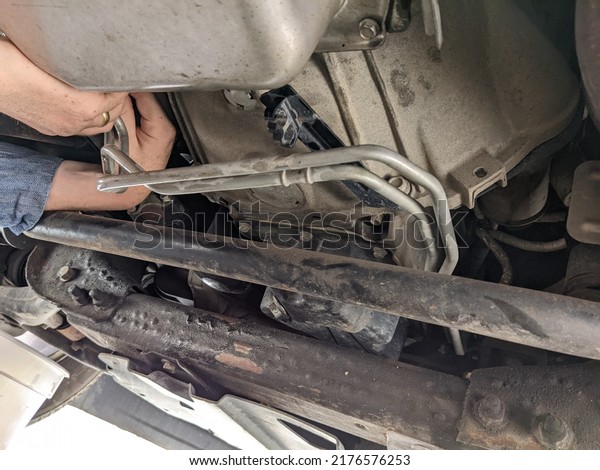 Mechanic Working on the Transmission Under a Car,\
Truck Transmission Oil\
Flush