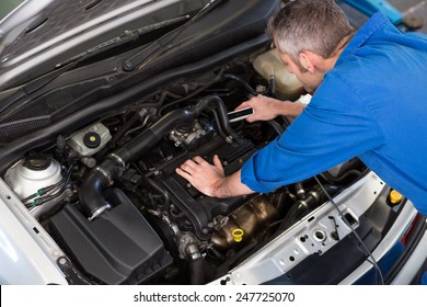 Mechanic Working Under The Hood At The Repair Garage