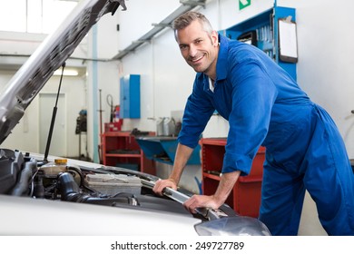 Mechanic Working Under The Hood At The Repair Garage