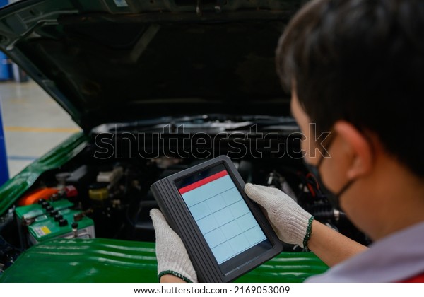 mechanic works at the car service center. Perform\
a vehicle diagnostic scan using the OBD and OBD2 device on the\
tablet to fix problems in the garage or repair shop. which is an\
electronic system
