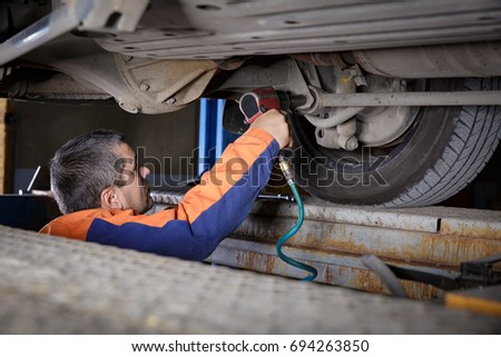 Mechanic Works on a Car. Repairs chassis