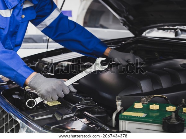 Mechanic works\
on the engine of the car in the garage.Concept of car inspection\
service and car repair\
service.