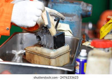Mechanic workshop activities in the process of cleaning engine carburetors