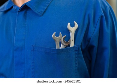 Mechanic with wrenches in pocket at the repair garage