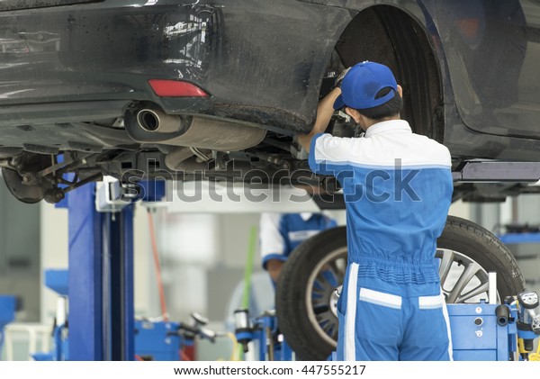 Mechanical\
checking car wheel in auto repair\
shop
