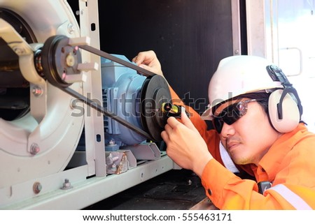 Mechanical engineer Aligning Sheave with Laser pointer for sheave alignment of blower and electric motor at offshore oil and gas platform, Oil and gas exploration and production.