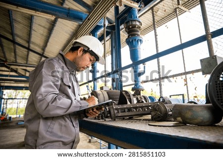 Mechanical Engineer Inspecting Industrial Pump Equipment During Preventive Maintenance at Water Plant