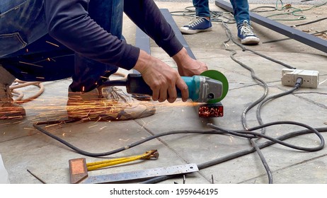Mechanical engineer using hacksaw to cut metal frame to build the roof