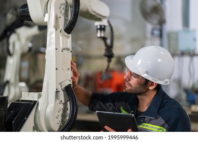 Mechanical engineer working for maintenance or repairing robotic welding machine in factory. Maintenance and repairing work in modern industry concept. - Powered by Shutterstock